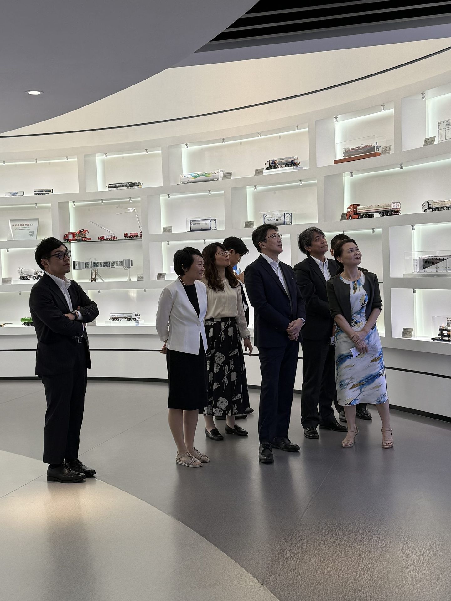 Visitors viewing CIMC equipment models displayed in the exhibition hall, including tank containers, trailers and road-transport vehicles